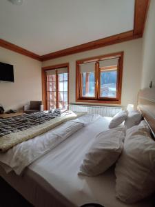 a large white bed in a room with windows at Apartment 216 NiM Vučko in Jahorina
