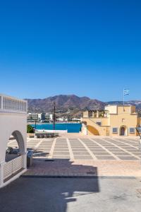 a parking lot with a view of the mountains at P i g a d i a B a y in Karpathos Town