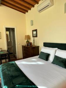 ein Schlafzimmer mit einem großen weißen Bett mit grünen Kissen in der Unterkunft La Limonaia Firenze in Florenz