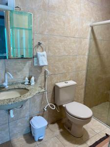 W łazience znajduje się toaleta, umywalka i lustro. w obiekcie Pousada Verdes Mares Porto De Galinhas w mieście Porto de Galinhas