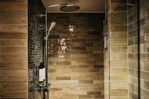 a shower in a bathroom with a brick wall at Bootshaus Amberg in Amberg