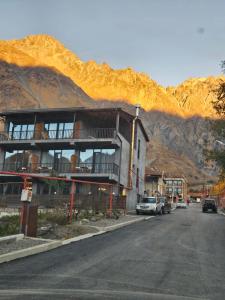 a building on the side of a street with a mountain at Best view Kazbegi in Stepantsminda