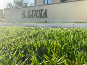 un campo de césped verde frente a un edificio en Affittacamere" SANTA LUCIA", en Roccarainola
