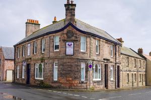 un viejo edificio de ladrillo al lado de una calle en One-Bedroom Apartment: Sleeps 4 Comfortably en Berwick-Upon-Tweed