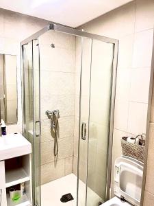 a shower with a glass door in a bathroom at Porte de mer Apartement in Essaouira +4 photos