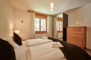um quarto com 2 camas brancas e uma cómoda em Apartment Silberhorn, outstanding view, spacious, family friendly em Lauterbrunnen