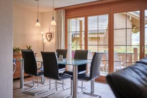 uma sala de jantar com uma mesa de vidro e cadeiras em Apartment Silberhorn, outstanding view, spacious, family friendly em Lauterbrunnen
