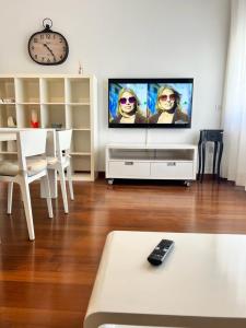 a living room with a tv with two people on the screen at Piazza Italia Luxury Apartment in Chianciano Terme
