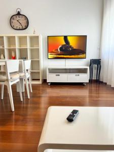 sala de estar con TV de pantalla plana en la pared en Piazza Italia Luxury Apartment en Chianciano Terme