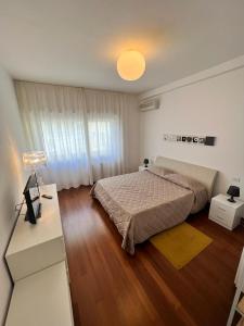 ein Schlafzimmer mit einem Bett und einem Schreibtisch mit einer Lampe in der Unterkunft Piazza Italia Luxury Apartment in Chianciano Terme