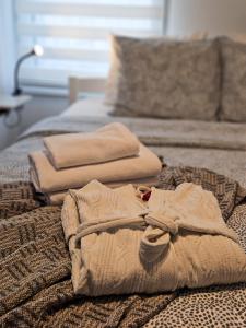 a bed with two folded towels on top of it at Roman Apartman in Sremska Mitrovica