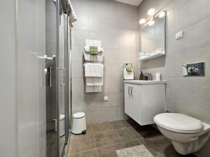 a bathroom with a toilet and a sink and a shower at Roman Apartman in Sremska Mitrovica