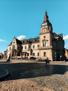 ein großes Gebäude mit einem Uhrturm auf einer Straße in der Unterkunft Ritters Weinstuben in Merseburg