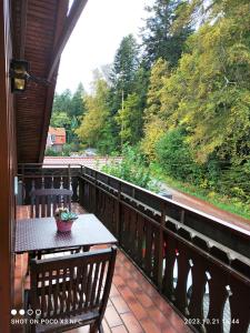 einen Balkon mit einem Tisch und Blick auf die Bäume in der Unterkunft Lieblingsort in Freudenstadt