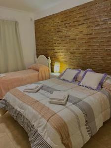 sypialnia z 2 łóżkami i ceglaną ścianą w obiekcie Complejo Pampa 1 w mieście Santa Rosa