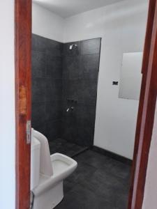 y baño con aseo blanco y ducha. en La Casona en San Pedro de Jujuy