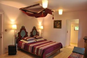 ein Schlafzimmer mit einem großen Bett in einem Zimmer in der Unterkunft Le Pavillon du Lac in La Brede