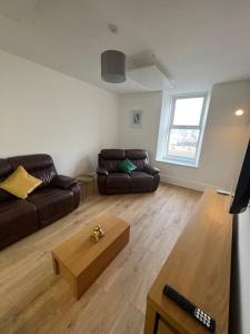 a living room with a couch and a coffee table at Substantial 5 Bed Townhouse in Peterhead
