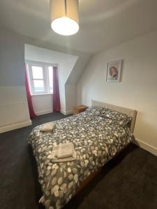 a bedroom with a bed in a room with a window at Substantial 5 Bed Townhouse in Peterhead