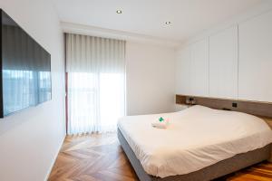 een witte slaapkamer met een bed in een kamer bij Dunvegan in Oostende