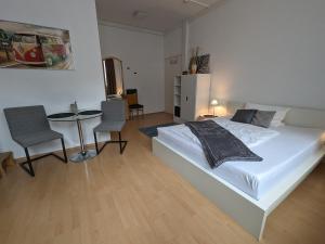 a bedroom with a bed and a table and chairs at Pension am Park in Pforzheim