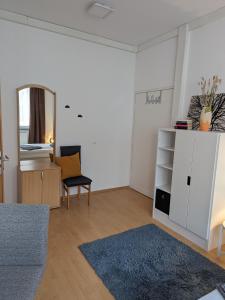 een witte woonkamer met een spiegel en een stoel bij Pension am Park in Pforzheim