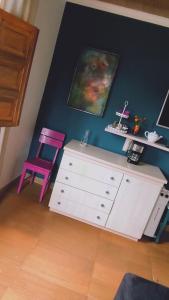 Zimmer mit einer weißen Kommode und einem rosa Stuhl in der Unterkunft Recanto Duas Rosas in Venda Nova do Imigrante