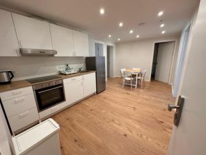 a kitchen with white cabinets and a table with a dining room at ELBI Apartment in Frankfurt/Main