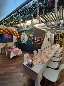 a dining room with white tables and white chairs at Vymar and Loto Azul in Pasto
