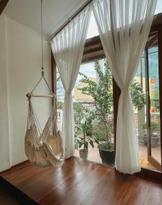 a room with a hammock in front of a window at Forest Tag - 6/8 Ha Noi in Hue