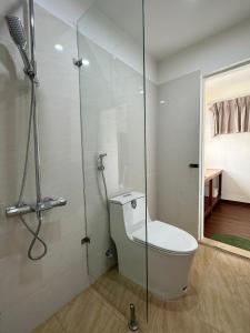 a bathroom with a toilet and a glass shower at Forest Tag - 6/8 Ha Noi in Hue