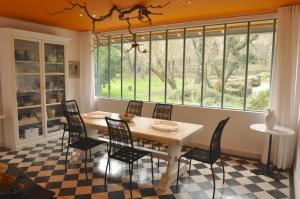 d'une salle à manger avec une table, des chaises et une fenêtre. dans l'établissement Le Pavillon du Lac, à La Brède