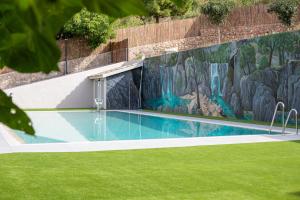 una piscina con un mural en la pared en Apartamentos 7 puentes sierra Cazorla, en Burunchel