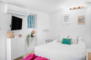 L'oiseau Bleu في أوباني: غرفة نوم بيضاء مع سرير وتلفزيون بشاشة مسطحة