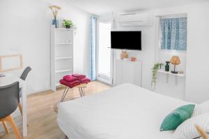 L'oiseau Bleu في أوباني: غرفة نوم بيضاء مع سرير وتلفزيون