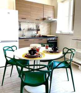 cocina con mesa y 4 sillas y cocina con cocina en Monkey house Appartamento in centro storico en Palermo