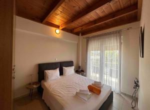 a bedroom with a large white bed with a window at Villa Papagiorgio Luxury and Harmony in Gennadi