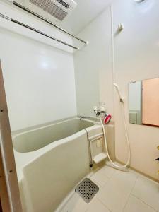 La salle de bains est pourvue d'une baignoire et d'un lavabo. dans l'établissement 大通公園1分　新規募集　6-2サービスアパートメントSAPPORO大通西6-2エアコン完備！ネット無料利用, à Ōdōri
