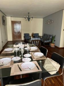 uma sala de jantar com uma mesa com pratos e copos de vinho em Excelente ubicación Cochabamba em Cochabamba