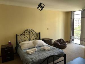 a bedroom with a bed with two towels on it at Excelente ubicación Cochabamba in Cochabamba