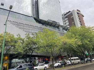 a city street with cars parked in front of a building at Excelente ubicación Cochabamba in Cochabamba +4 photos