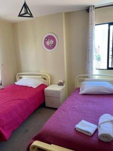 um quarto com 2 camas com lençóis cor-de-rosa e uma janela em Excelente ubicación Cochabamba em Cochabamba