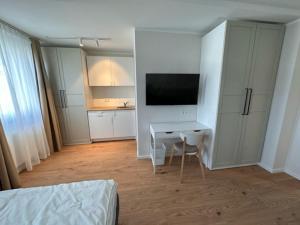 ein Schlafzimmer mit einem Schreibtisch und einem TV in einem Zimmer in der Unterkunft ELBI Apartment in Frankfurt am Main
