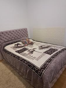 a bed with a quilt on it in a room at Sara apartman in Novi Grad