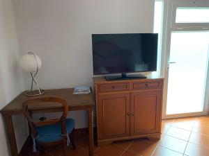 a desk with a television and a chair in a room at Da Francesca in Lucca