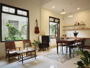 a living room with a table and chairs and a guitar at Forest Tag - 6/8 Ha Noi in Hue
