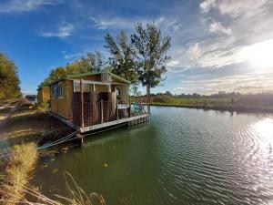 にあるCottage flottant terrasse jacuzzi option aux Portes de Dijonの水の上の桟橋