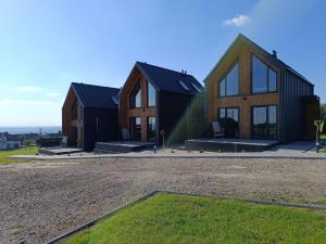 un grupo de tres casas en un campo en Domki Pod Łysicą, en Krajno Pierwsze