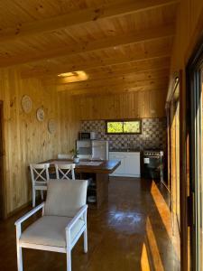 - une cuisine avec une table et des chaises dans la chambre dans l'établissement Cabaña en Pupuya Navidad, à Navidad