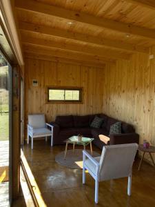 sala de estar con sofá y mesa en Cabaña en Pupuya Navidad, en Navidad